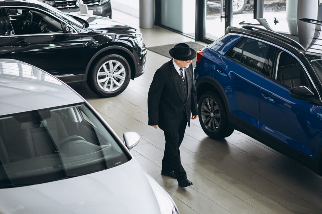 senior business man in a car showroom choosing a car